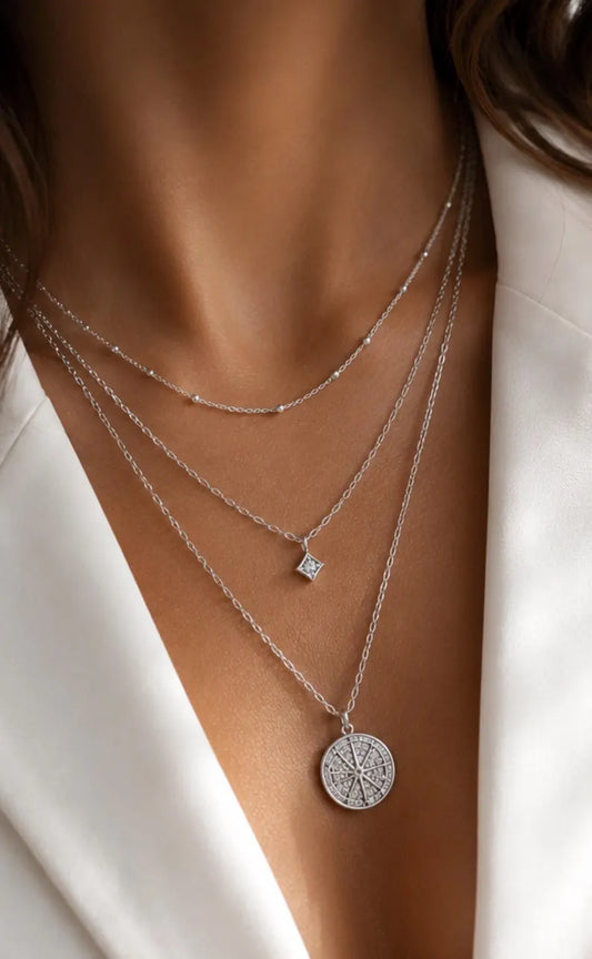 Woman wearing layered necklaces with different lengths and a meaningful pendant
