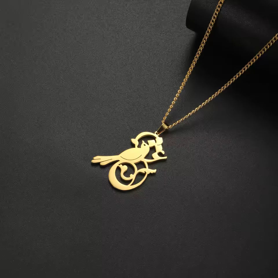 Gold bird-shaped pendant on a chain against a black background