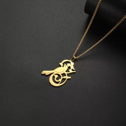 Gold bird-shaped pendant on a chain against a black background