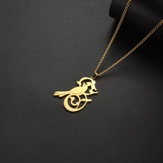 Gold bird-shaped pendant on a chain against a black background