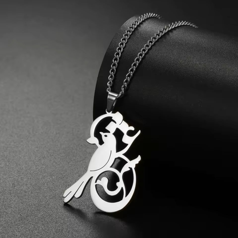 Silver bird pendant necklace on a dark background