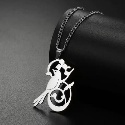 Silver bird pendant necklace on a dark background