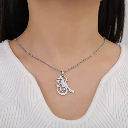 Silver necklace with a pendant on a mannequin wearing a white sweater.