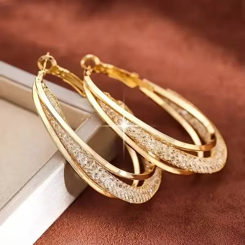 Gold crystal hoop earrings for women with twisted metal design
