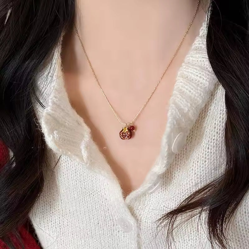 Necklace with a pendant worn by a person in a white sweater