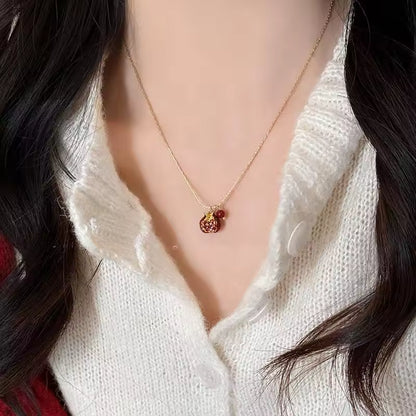 Necklace with a pendant worn by a person in a white sweater