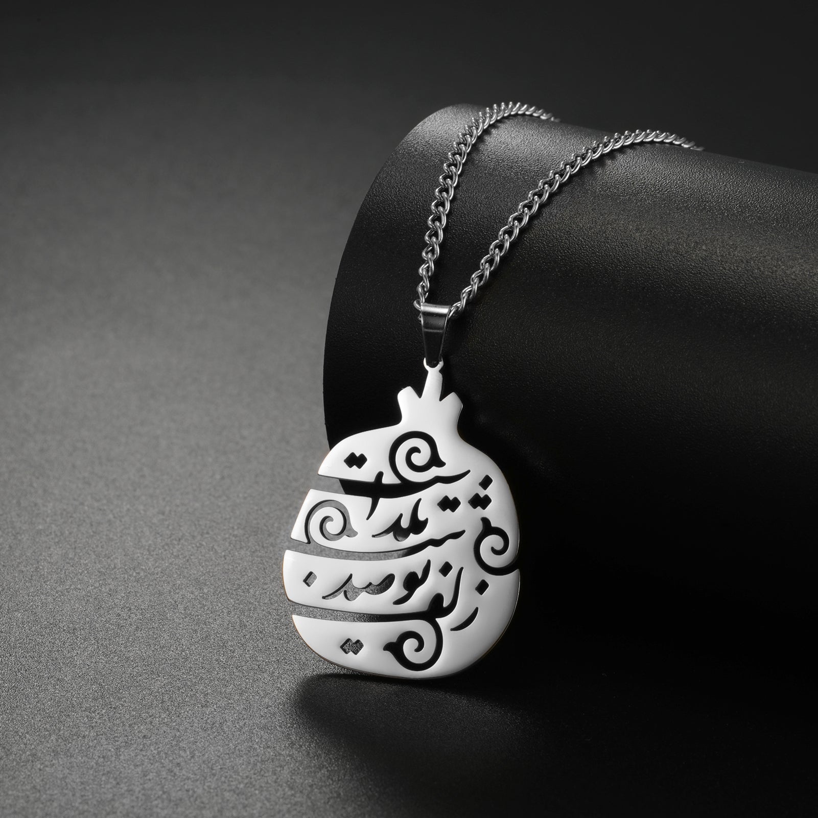 Yalda Persian poem necklace displayed on a neutral background, showcasing Farsi calligraphy design.